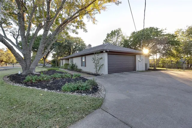 a view of a house with a large tree and a yard