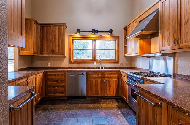 a kitchen with stainless steel appliances granite countertop a stove a sink and a microwave
