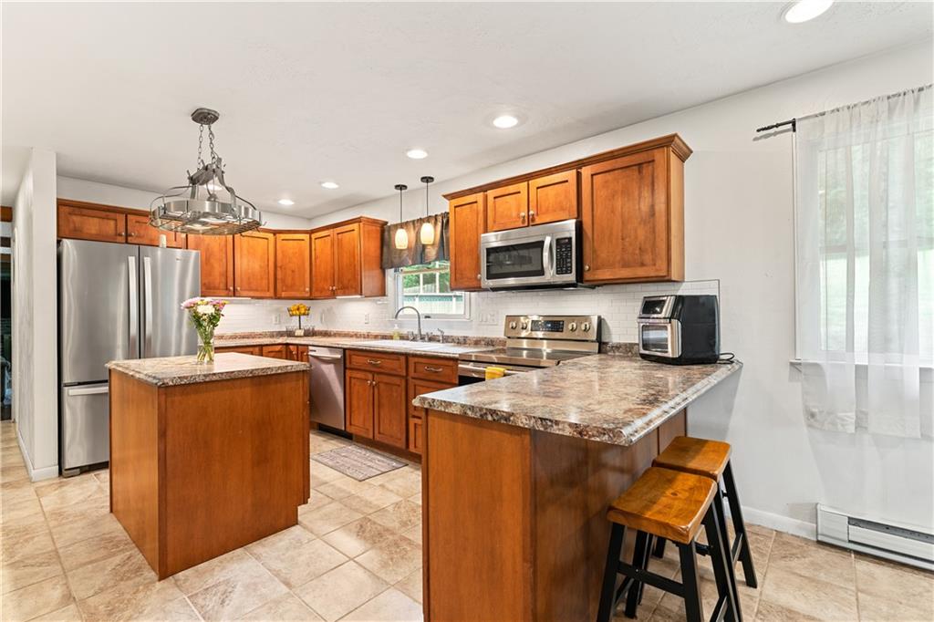 154 Central Road Tarrs, PA 15688 - Photo 9 of 24 a kitchen with stainless steel appliances granite countertop a stove top oven a sink dishwasher and a refrigerator with wooden cabinets