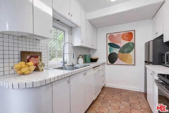 a kitchen with stainless steel appliances a sink a stove and cabinets