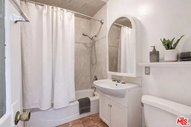 a bathroom with a sink a mirror and a shower curtain
