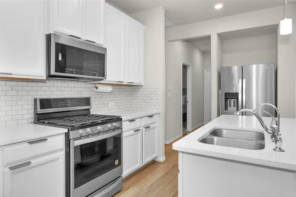 a kitchen with sink stove and microwave