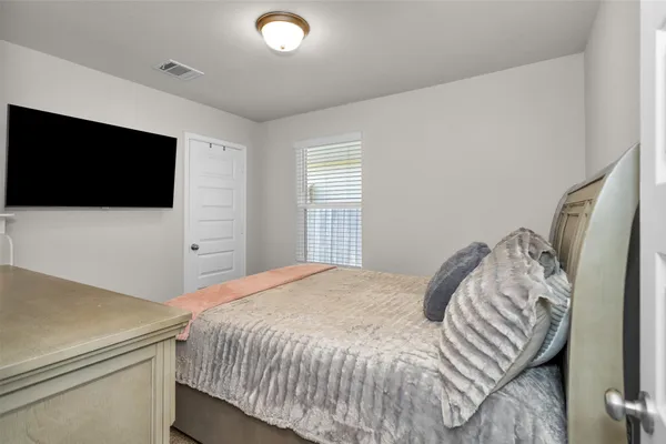 a bedroom with a bed and a flat screen tv