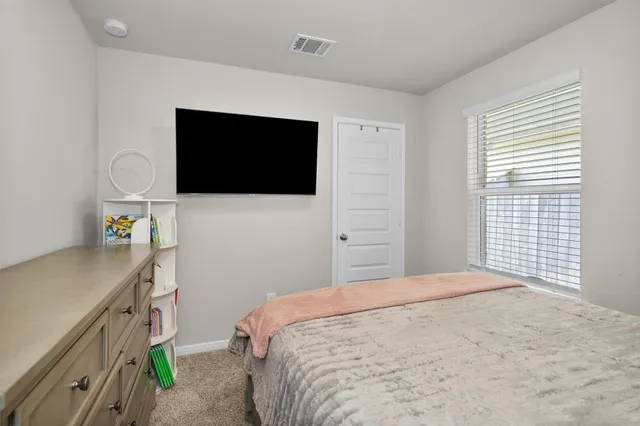 a bedroom with a bed and a flat screen tv