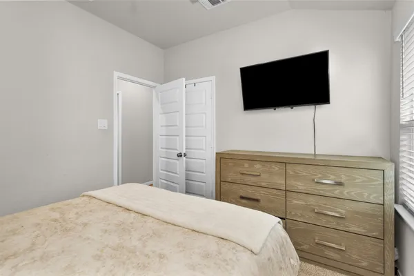 a bedroom with a bed and a flat screen tv