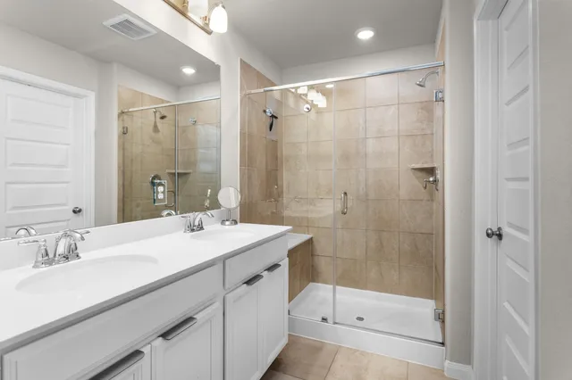 a bathroom with a shower sink vanity and mirror