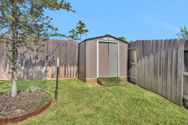 a view of backyard with potted plants and wooden fence