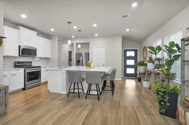 a kitchen with a table chairs refrigerator and microwave