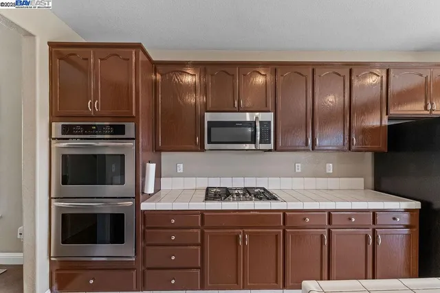 a kitchen with stainless steel appliances granite countertop a stove microwave and refrigerator