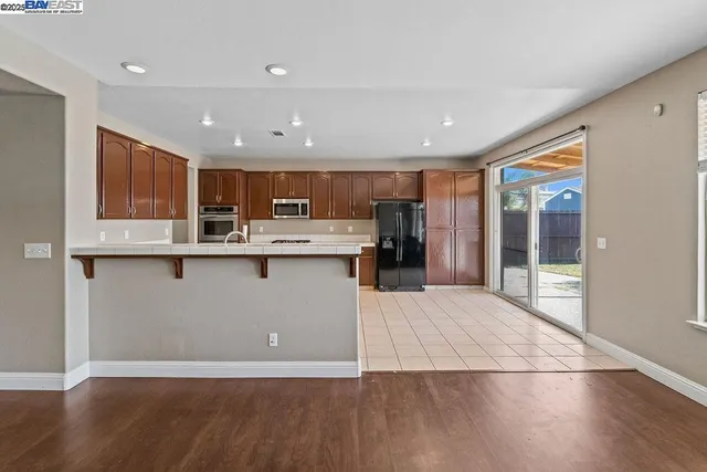 a kitchen with stainless steel appliances granite countertop a refrigerator a sink a stove and oven