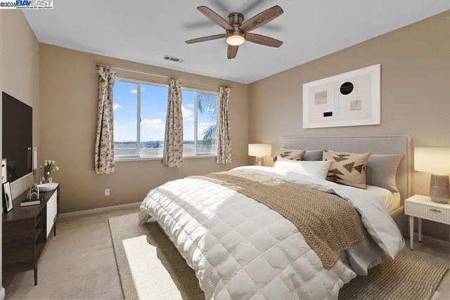 an empty room with windows and fan