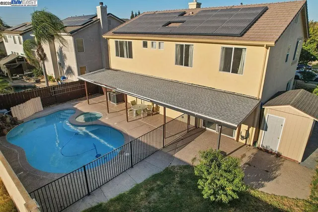 a view of a house with backyard and sitting area