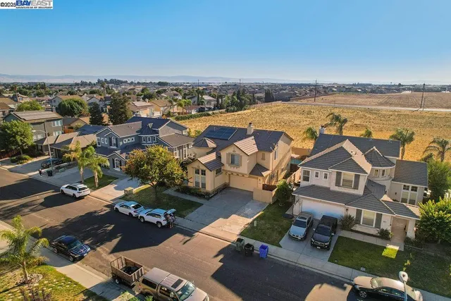 an aerial view of ocean and residential houses with outdoor space