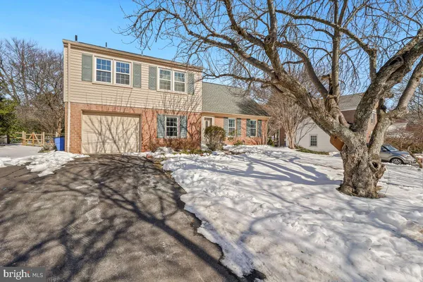a front view of a house with a yard covered in snow