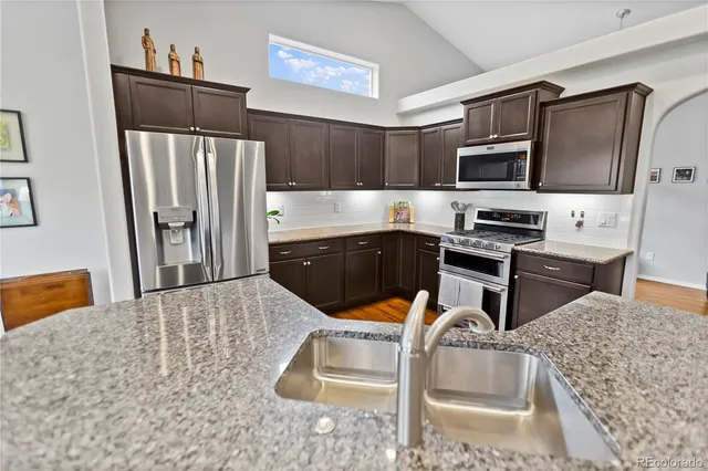 a kitchen with stainless steel appliances a stove a refrigerator and a sink