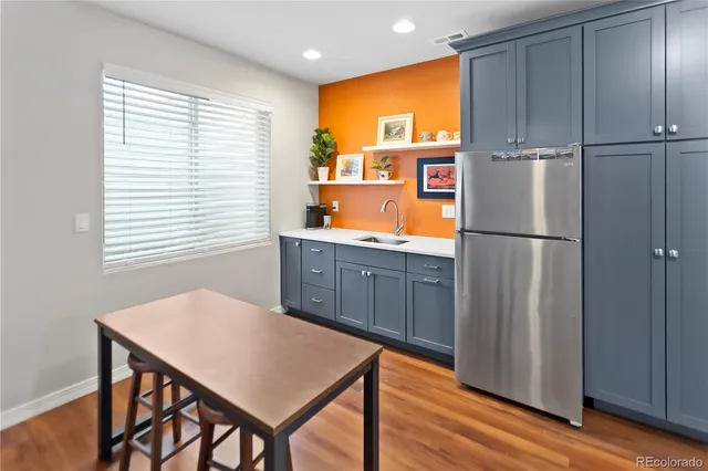 a kitchen with stainless steel appliances a refrigerator table and chairs