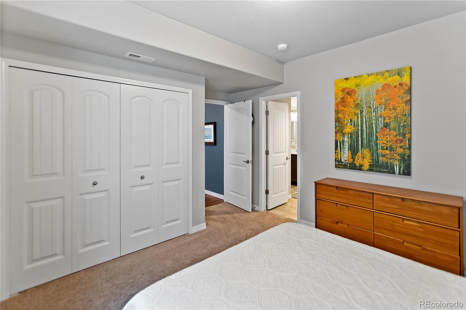 10687 Hidden Brook Circle Colorado Springs, CO 80908 - Photo 10 of 36 a spacious bedroom with a bed and a dresser next to a window
