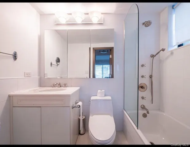 a bathroom with a toilet sink shower and mirror