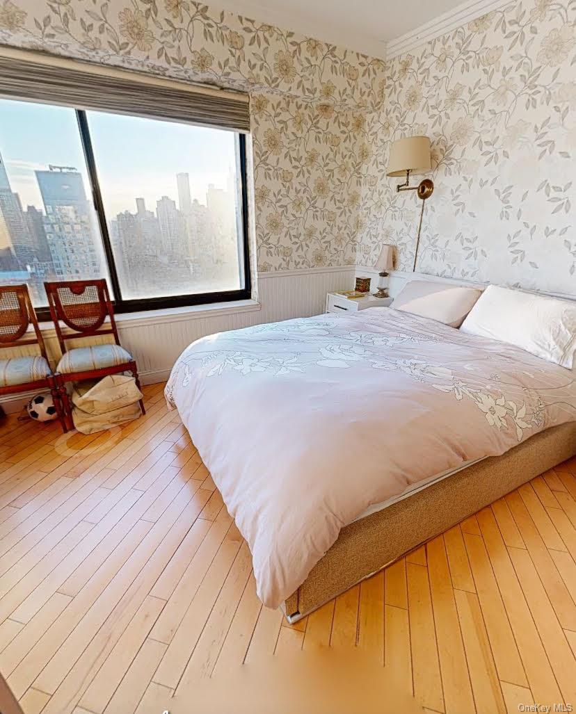 400 East 70th Street, Unit 3501 Manhattan, NY 10021 - Photo 18 of 21 a bedroom with a bed and wooden floor
