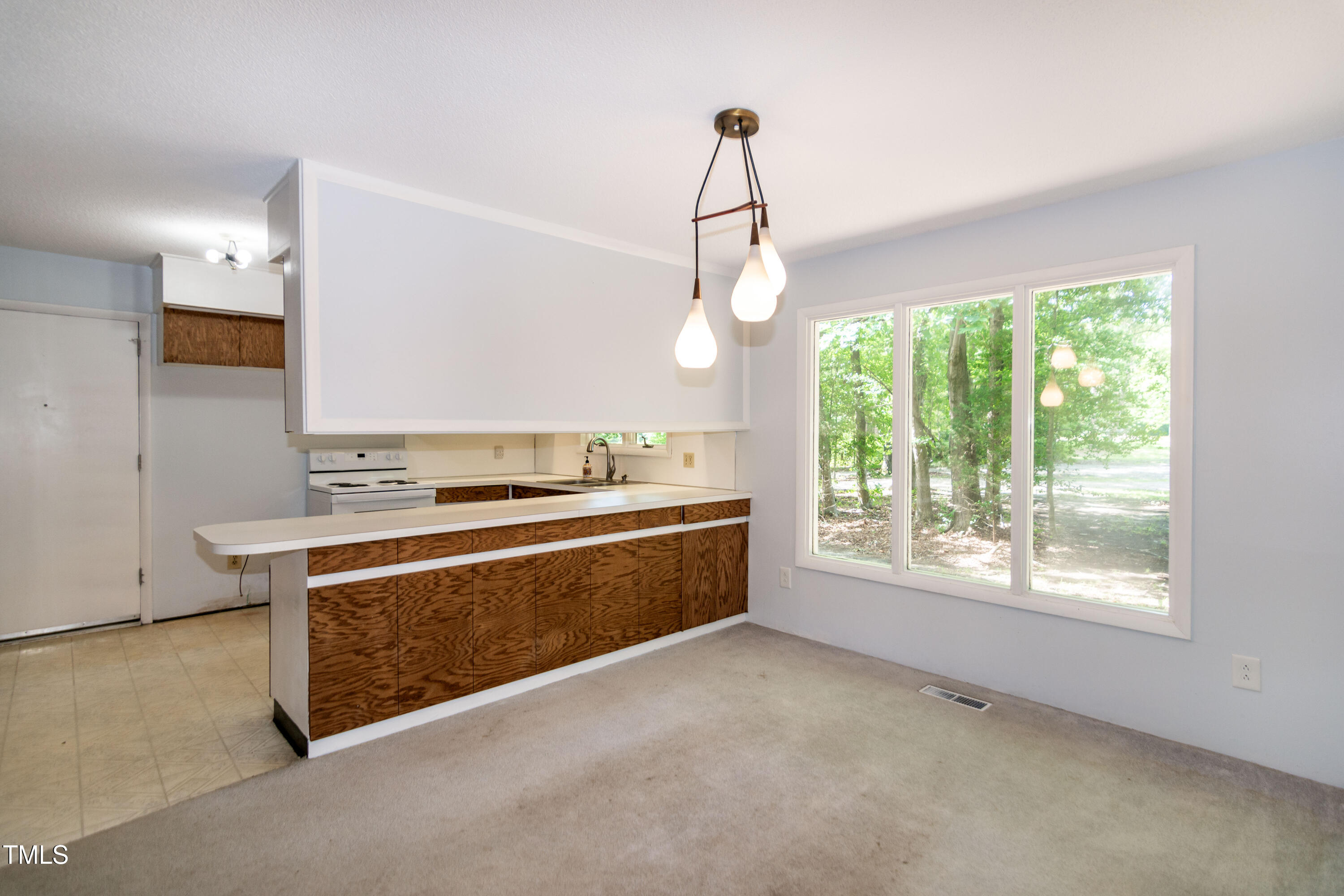 5213 Tomahawk Trail Raleigh, NC 27610 - Photo 10 of 80 a view of a kitchen with a stove wooden cabinets and a floor to ceiling window
