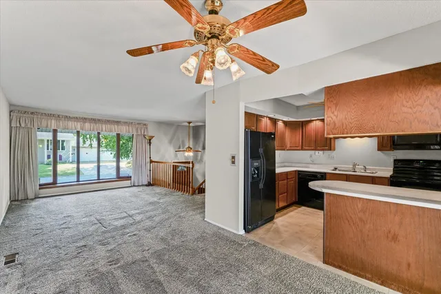 a kitchen with stainless steel appliances granite countertop a stove a refrigerator a sink a oven with a dining table and chairs