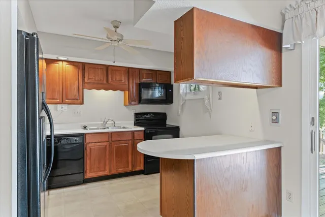 a kitchen with stainless steel appliances a sink a stove a refrigerator cabinets and a dining table