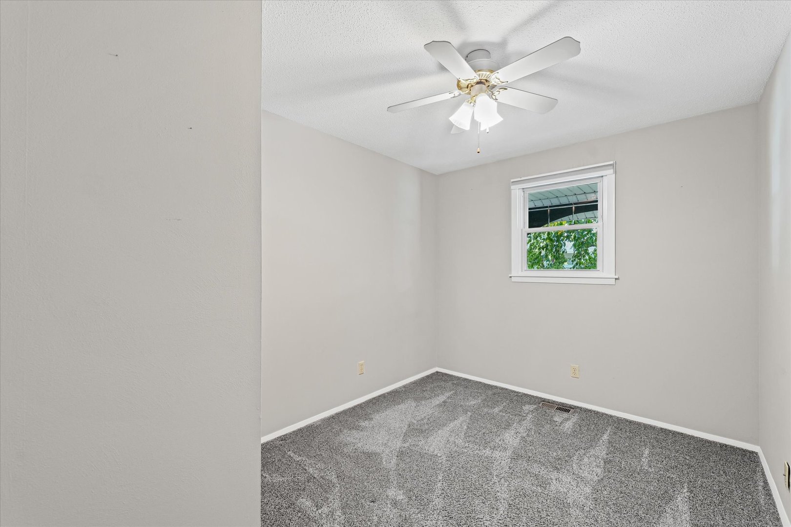 1613 Carolina Drive Rantoul, IL 61866 - Photo 24 of 50 an empty room with a chandelier fan and windows