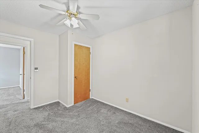 an empty room with a ceiling fan and a chandelier fan