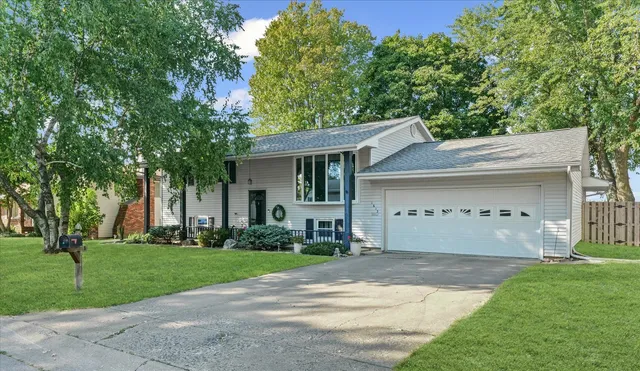 a front view of a house with a yard and trees