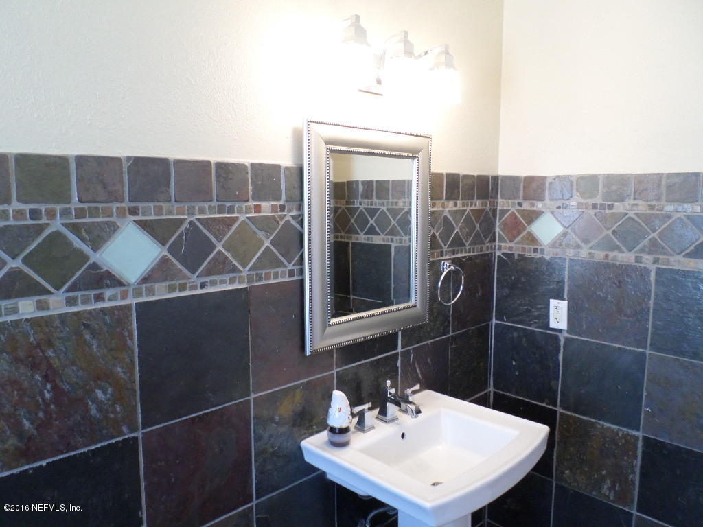 4237 Stacey Road Jacksonville, FL 32250 - Photo 12 of 22 a bathroom with a sink a mirror and a shower