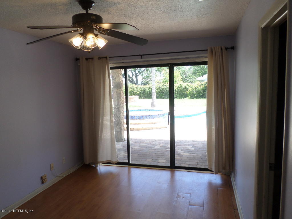 4237 Stacey Road Jacksonville, FL 32250 - Photo 13 of 22 a view of an empty room with wooden floor and a window