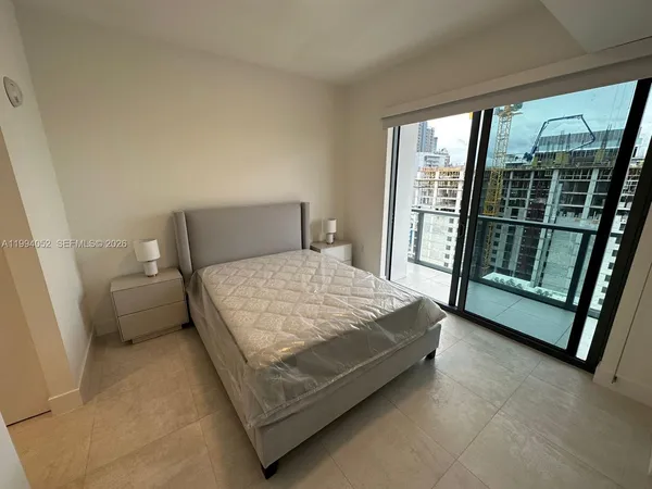 a bedroom with a bed and large window