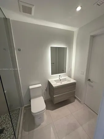 a bathroom with a sink a toilet and mirror
