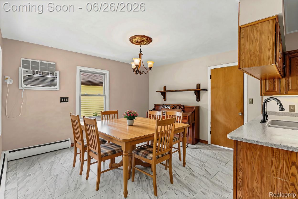 5366 East Mt Morris Road Mount Morris, MI 48458 - Photo 17 of 57 AI Edited Dining area featuring grey patterned tile flooring, a window with horizontal blinds, and a bronze chandelier with an ornate ceiling medallion