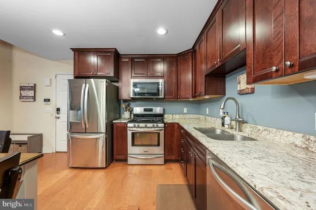 a kitchen with stainless steel appliances granite countertop a refrigerator stove microwave and sink