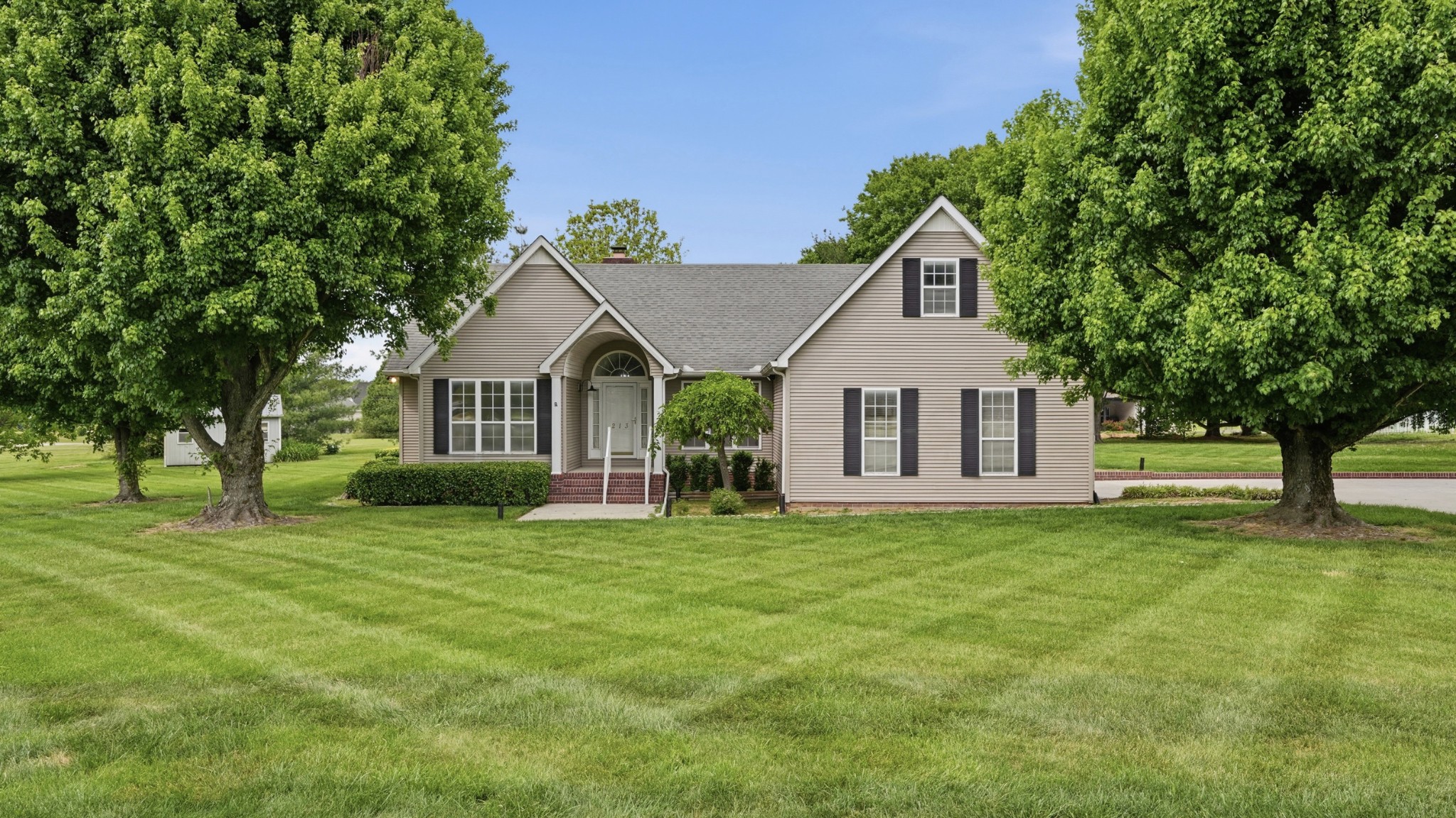 213 Maple Springs Drive Manchester, TN 37355 - Photo 2 of 58 a front view of a house with a yard
