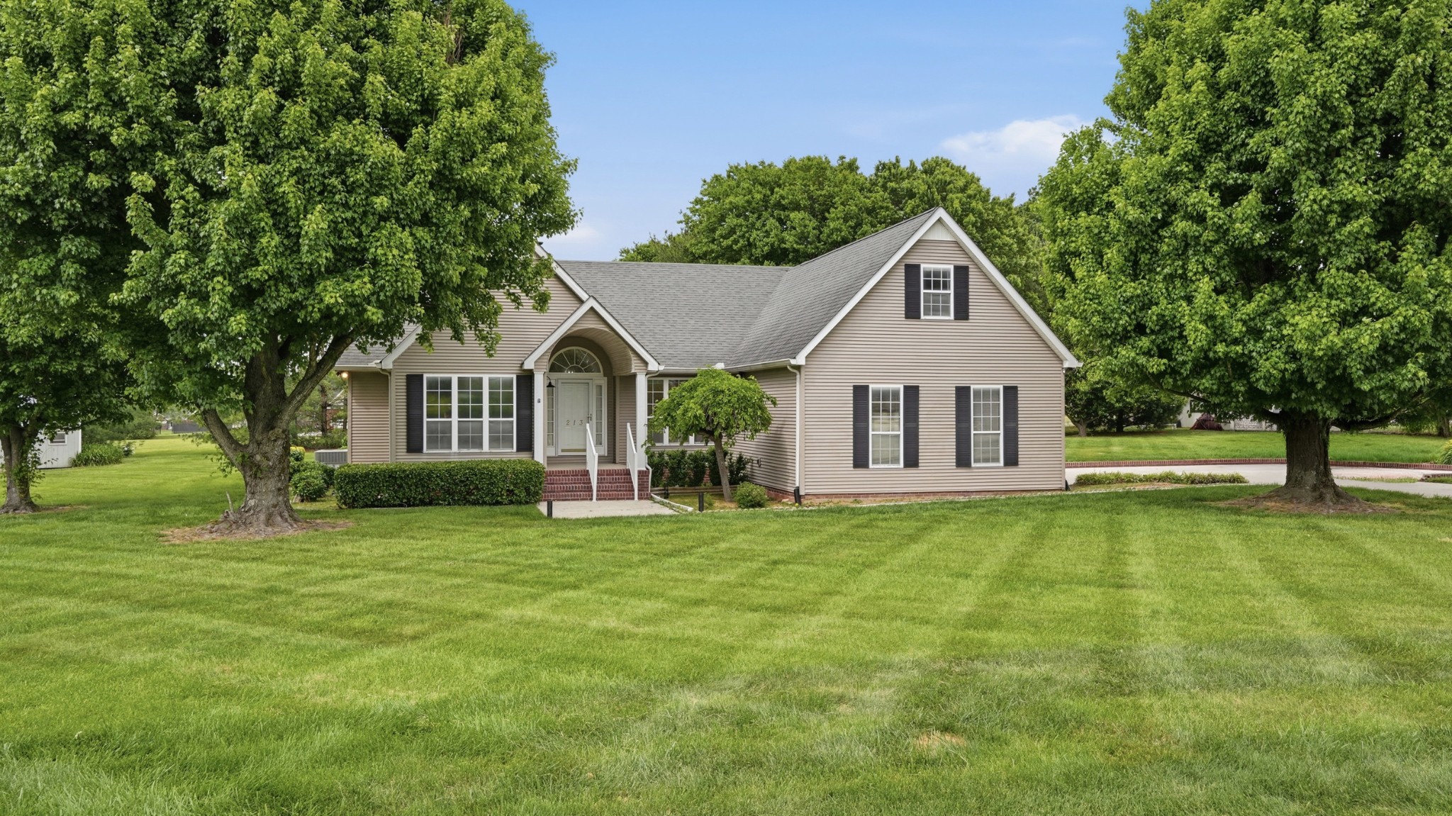 213 Maple Springs Drive Manchester, TN 37355 - Photo 40 of 58 a front view of a house with a garden