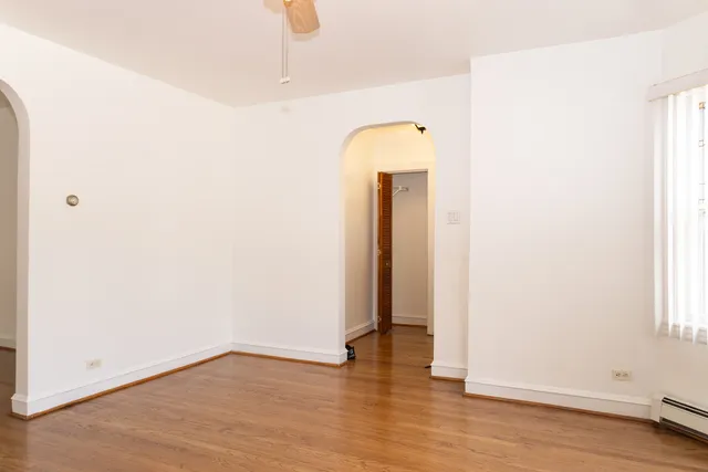 an empty room with wooden floor and mirror