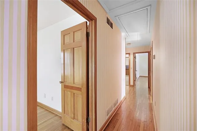 a view of a hallway with wooden floor and entryway
