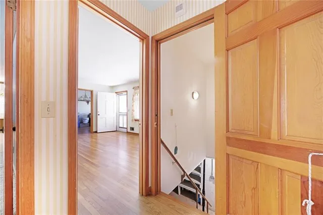 a view of a hallway with wooden floor and staircase