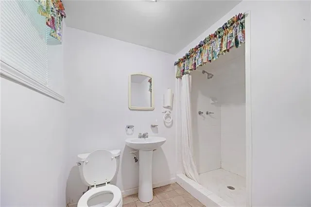 a bathroom with a shower a toilet and a sink