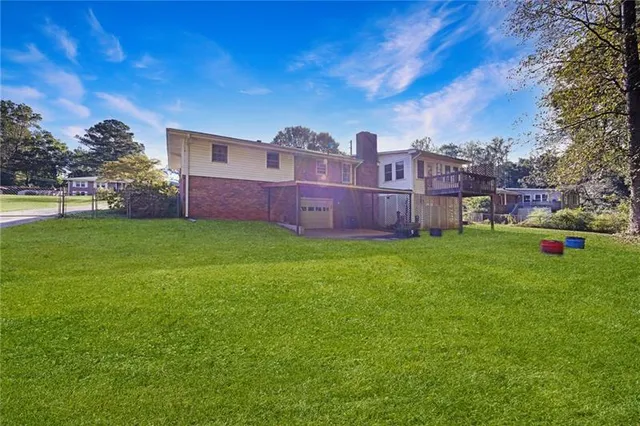 a view of a house with a big yard and large trees