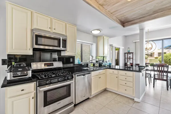a kitchen with stainless steel appliances granite countertop a stove microwave and cabinets