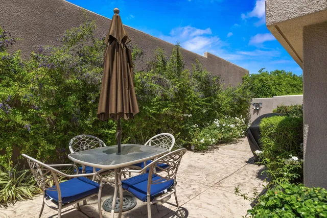 a backyard of a house with table and chairs