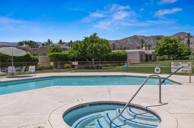 a view of a swimming pool with a yard and sitting area