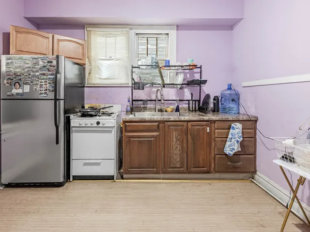 a utility room with a stove top oven a sink and cabinets