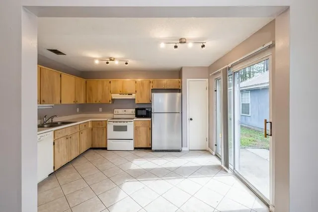 a large kitchen with a large window and stainless steel appliances