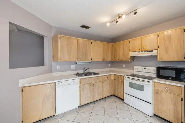 a kitchen with white cabinets appliances and a sink