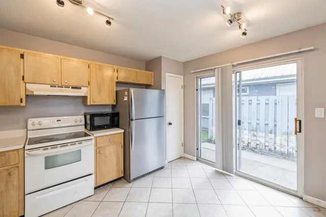 a kitchen with a stove a refrigerator and a cabinets