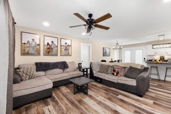 a living room with furniture and a view of kitchen